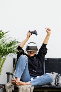 An image of a young lady on a sofa excited while using VR glasses; to depict the vivi visuals the field studies adventure will provide.