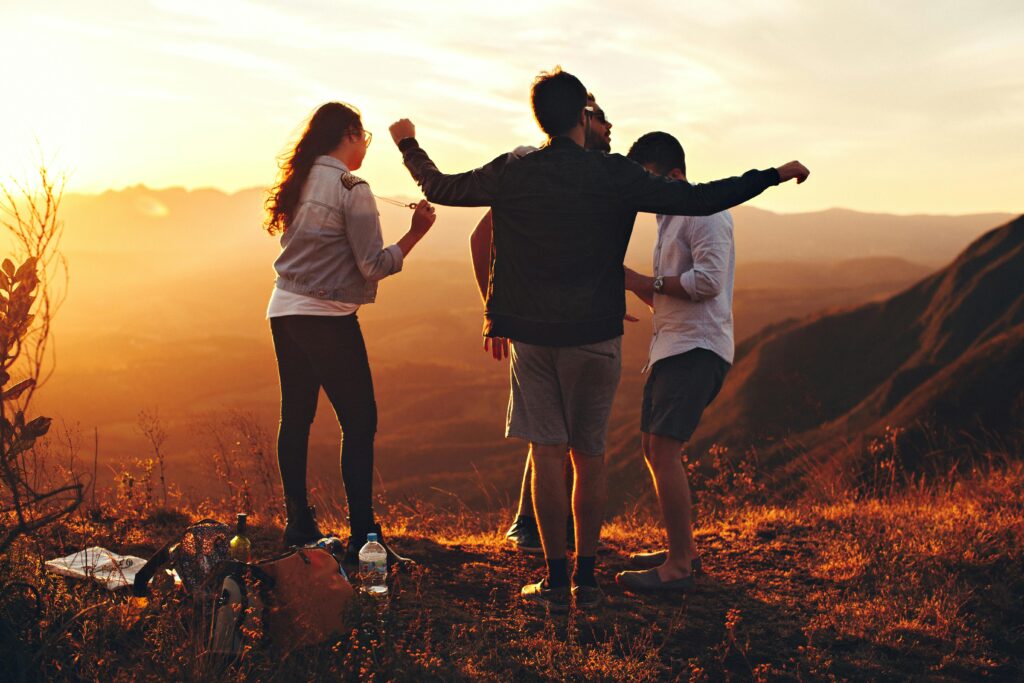 An image of students standing at the edge of a hill with a golden sunset in the horizon, probably on a forest trip to study climate change mitigations 